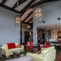 Chalet Ilaali Charlevoix, avec grand salon spacieux et confortable ouvert aux autres pieces de vie commune.