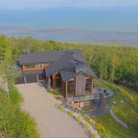 Ilaali se tenant debout au-dessus du Fleuve St-Laurent, parmi le paysage montagneux de Charlevoix.