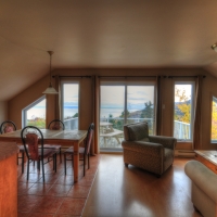 Air ouverte avec vue sur le fleuve et la montagne du Massif, cuisine et salle à dîner du Loft,  Le Pied de Vent en location, Petite-Rivière-Saint-François, Charlevoix, Les Versants, Ski Le Massif