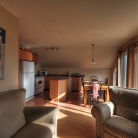 Air ouverte avec vue sur le fleuve et la montagne du Massif, cuisine, salon et salle à dîner du Loft,  Le Pied de Vent en location, Petite-Rivière-Saint-François, Charlevoix, Les Versants, Ski Le Massif