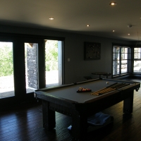 Chalet Ilaali a louer dans Charlevoix, avec sa salle de jeux menant au spa à l'extérieur